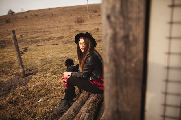 Happy young woman sitting with her black dog 