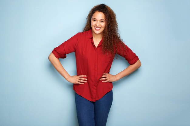 Happy young woman smiling against blue background