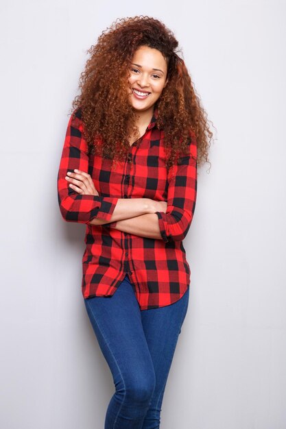 Happy young woman smiling against gray wall