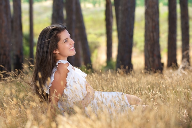 牧草地に笑顔で幸せな若い女性