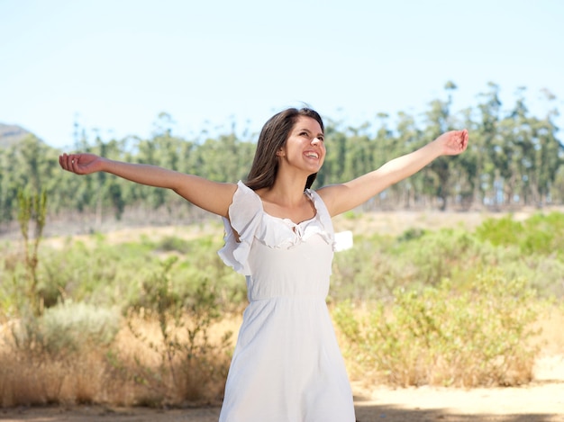 Happy young woman smiling with arms spread open