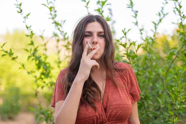 시골에서 담배를 피우는 행복한 젊은 여성