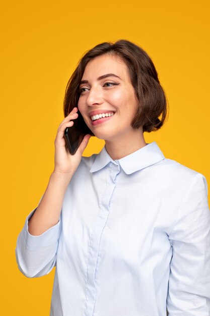 Happy young woman speaking on smartphone