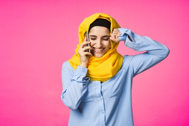 Photo happy young woman standing against pink background