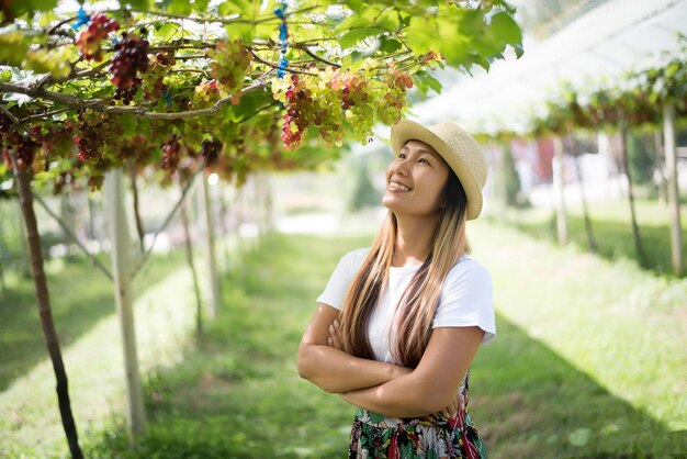 写真 植物に寄り添って立っている幸せな若い女性