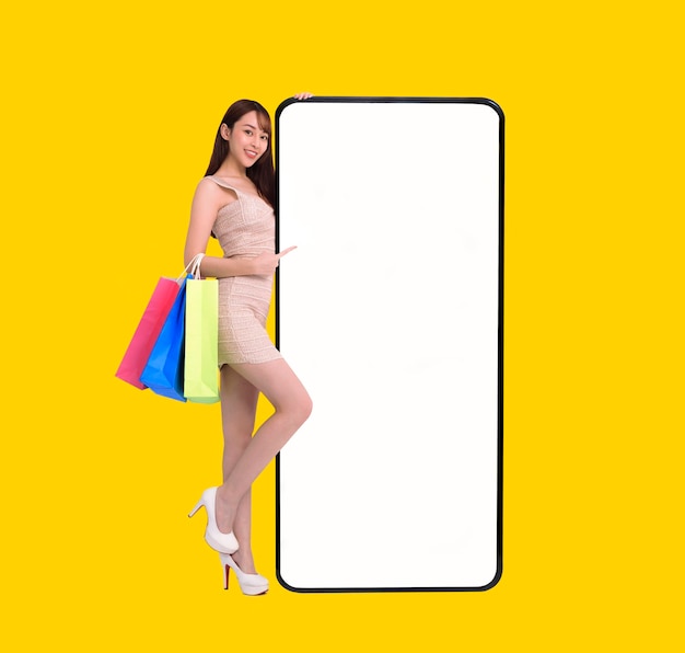 Happy young woman standing and Leaning big Smartphone With Blank White Screen shopping online with mobile phone concepts