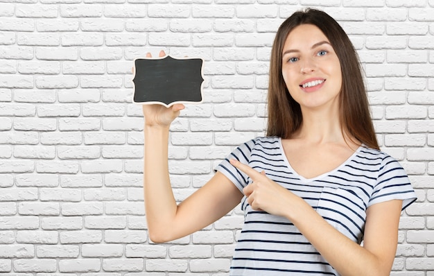 Happy young woman standing and showing copyspace