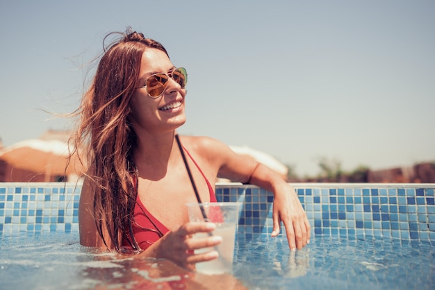 Happy young woman in the swimming pool