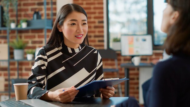 Happy young woman taking interview at office