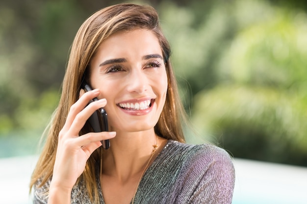 Happy young woman talking on mobile phone