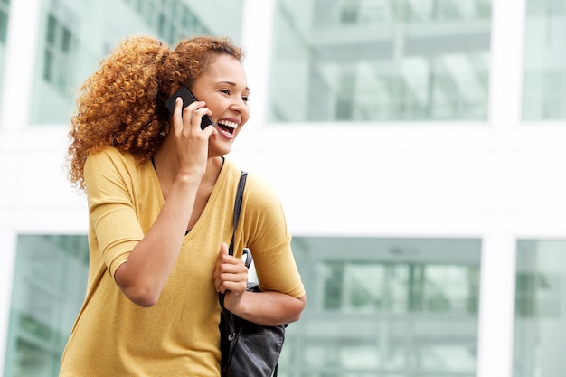 Foto felice giovane donna che parla con il cellulare in città