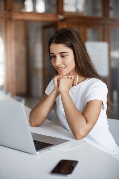 Happy young woman using laptop computer to call her parents abroad looking in web camera smiling Communications concept