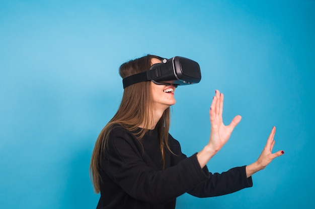 Happy young woman using a virtual reality headset.
