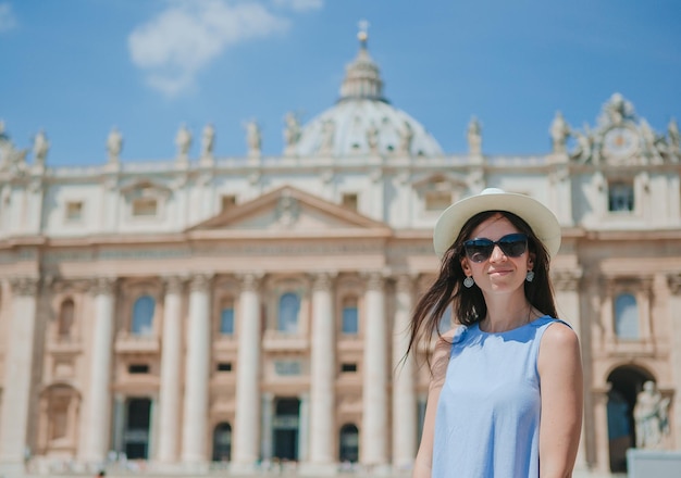 Happy young woman in vatican city and st peters basilica church rome italy