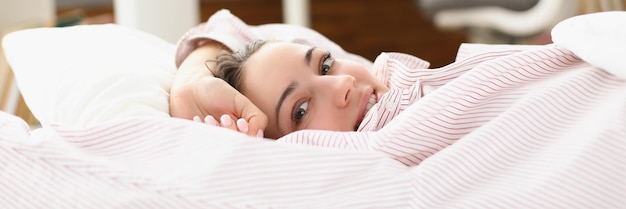 Photo happy young woman waking up in cozy home bed in good mood