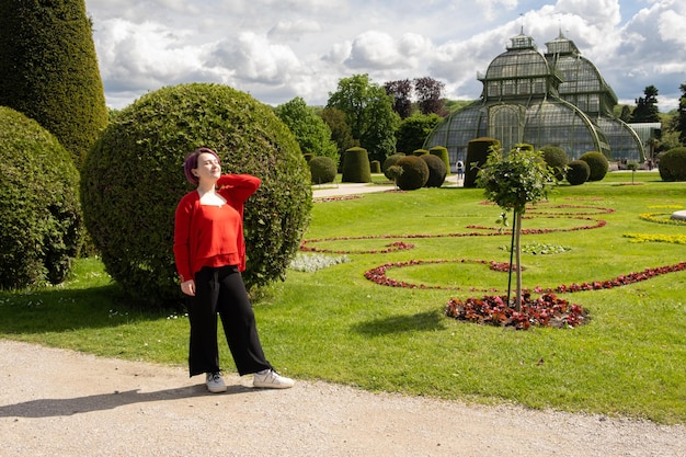 Happy young woman walking in beautiful European park her eyes closed enjoying the sun