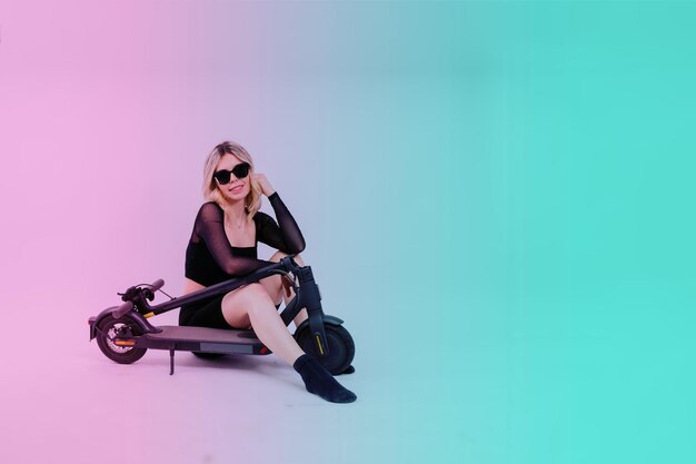 Happy young woman wear glasses riding electric scooter on background studio people lifestyle concept