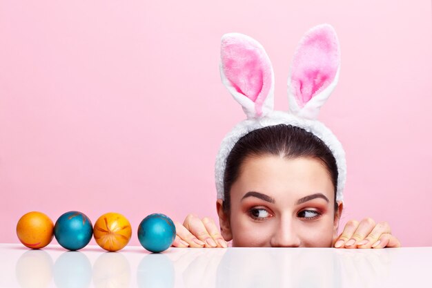 Happy young woman wearing bunny ears and having Easter Eggs