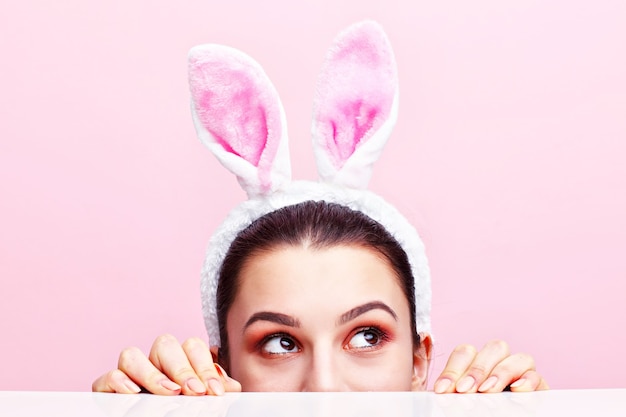 a happy young woman wearing bunny ears
