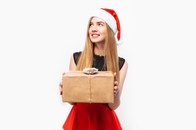 Foto felice giovane donna che indossa un vestito e un cappello da babbo natale