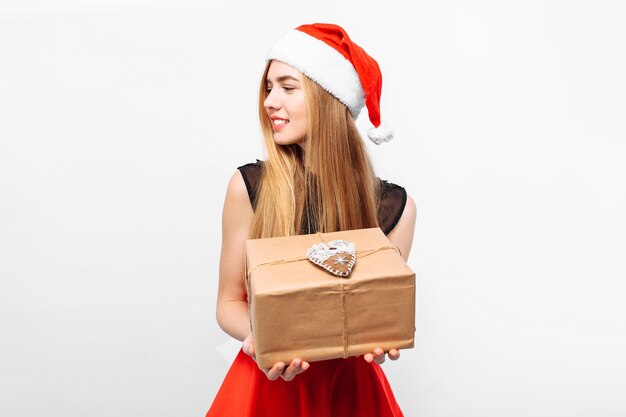 Foto felice giovane donna che indossa un vestito e un cappello da babbo natale