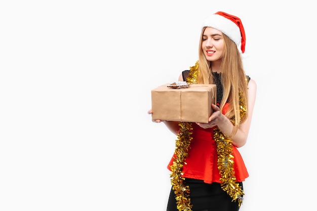 Foto felice giovane donna che indossa un vestito e un cappello da babbo natale