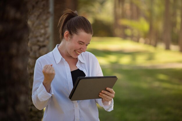 태블릿을 사용하여 일자리를 찾은 행복한 젊은 여성