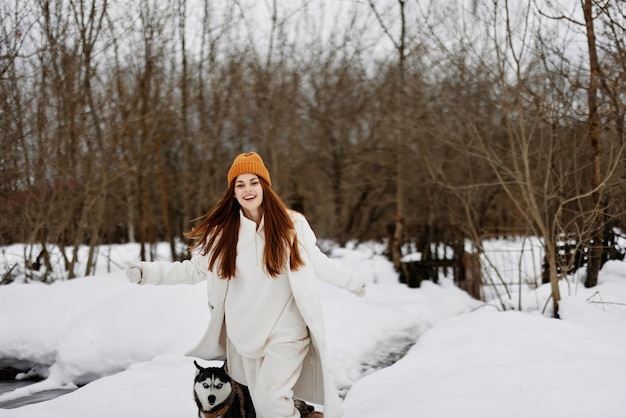 Happy young woman in winter clothes in a hat fun winter\
landscape walk in the winter forest high quality photo
