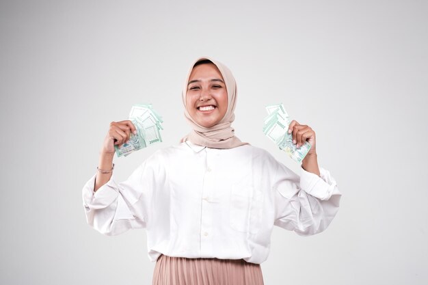 Happy young woman with cash money on white background