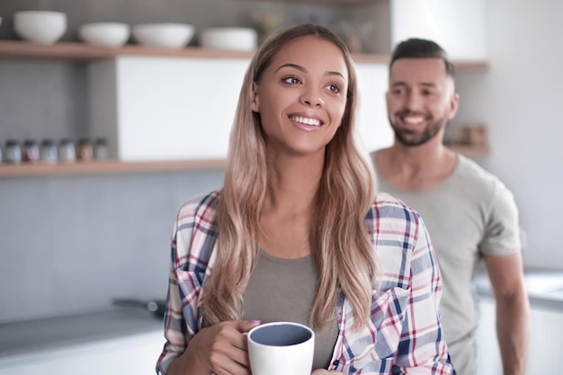 コーヒーのカップを持つ幸せな若い女性