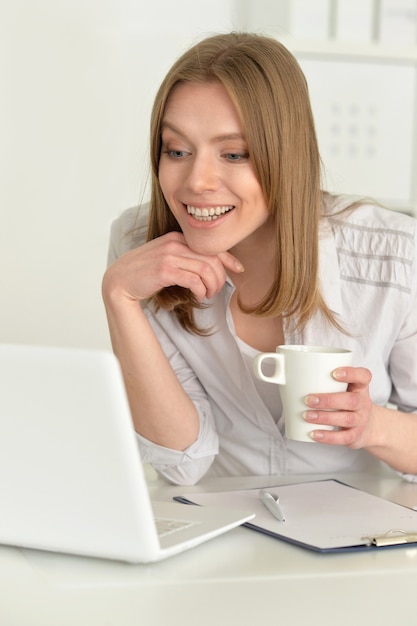 Happy young woman   with laptop at home
