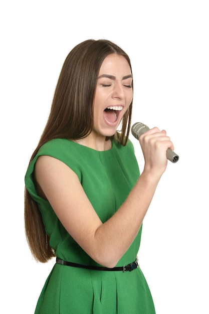 Happy young woman with microphone on white background