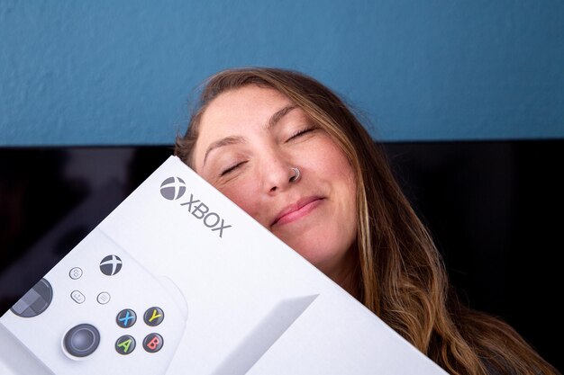 Happy young woman with a New video game console Xbox Series S