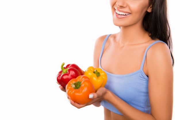 Happy young woman with peppers