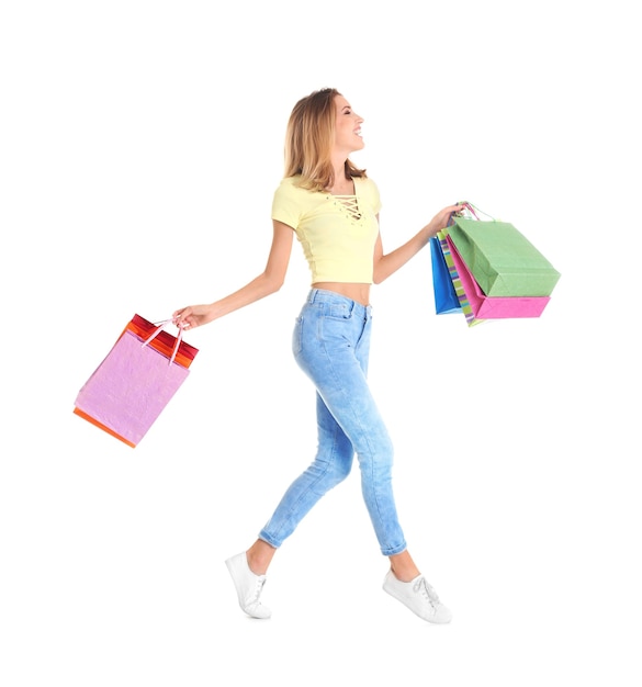 Happy young woman with shopping bags on white background