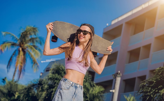 Happy young woman with skateboard enjoy longboarding at the skatepark