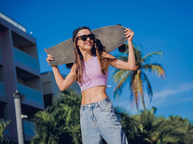 Happy young woman with skateboard enjoy longboarding at the skatepark