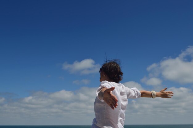 Photo happy young woman with spreading arms to sky