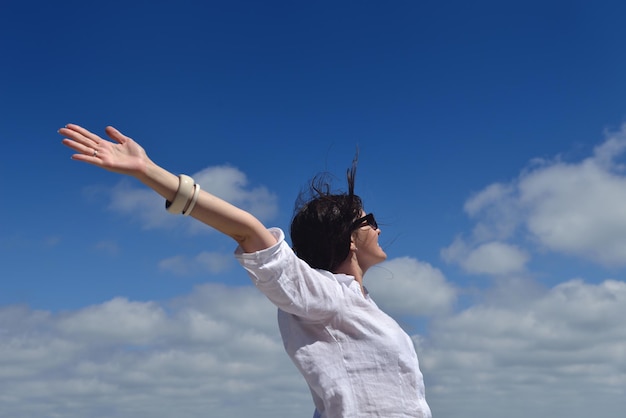 Photo happy young woman with spreading arms to sky