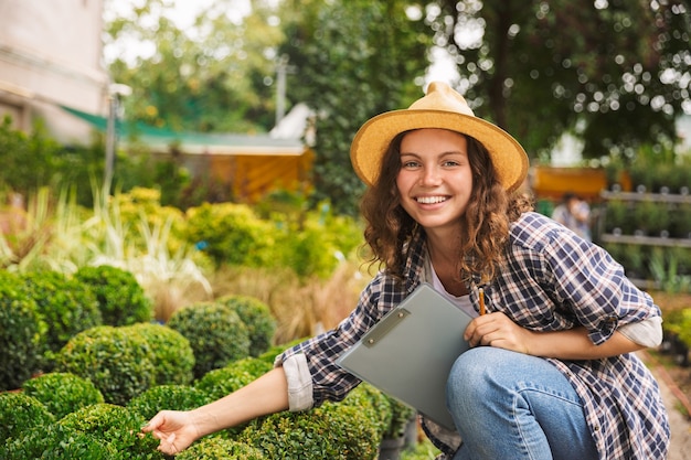 Happy young woman working in a greenhouse