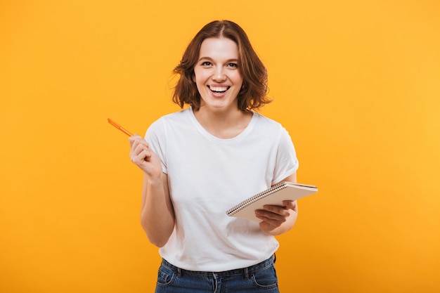 Happy young woman writing notes. looking camera.