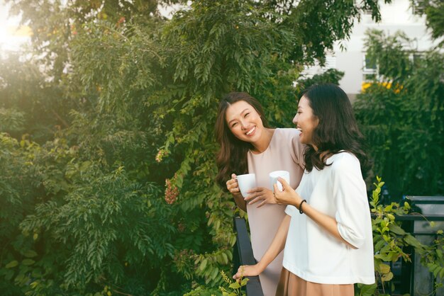 Photo happy young women friends well-dressed smiling while standing together