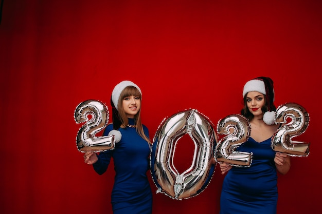 Photo happy young women holding silver 2022 balloons for celebrating merry christmas and happy new year