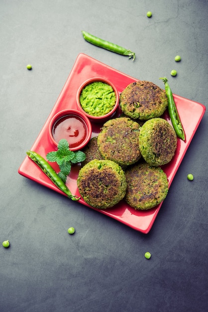 Hara bhara kabab or kebab is indian vegetarian snack recipe\
served with green mint chutney over moody surface. selective\
focus