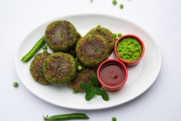 Hara bhara Kabab of Kebab is een Indiaas vegetarisch snackrecept geserveerd met groene muntchutney op een humeurig oppervlak. selectieve focus