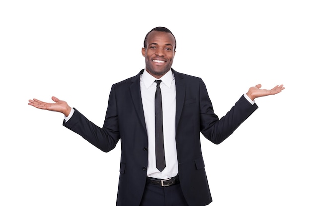 Hard choice. Cheerful young African man in formalwear gesturing and smiling while standing isolated on white background