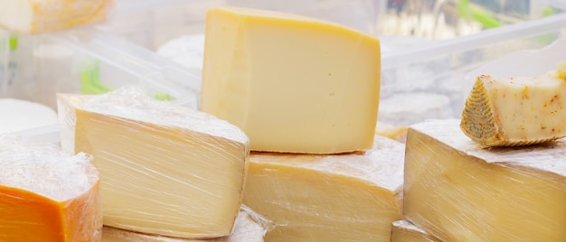 Hard goat cheese on the table. Many varieties of craft cheese are on the counter during the cheese festival. Dairy product sales concept