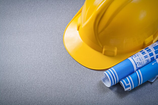 Hard hat blue blueprints on grey background construction concept