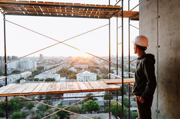 Hard hat builder inside building under construction