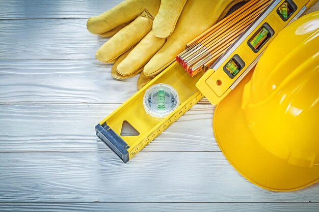 Hard hat protective gloves construction level on white board